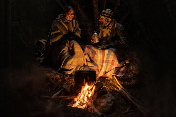 two people chating besides a camp fire